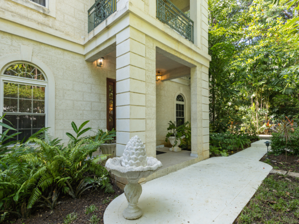 Stunning exterior view of Mon Caprice, a luxury home in Sandy Lane, showcasing lush gardens and classic architecture in Barbados.
