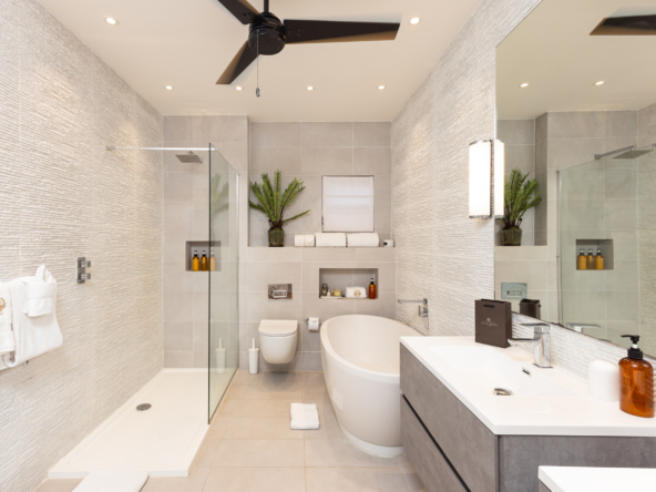 Barbados luxury modern beachfront villa guest suite with bathroom featuring two sinks, bath and shower