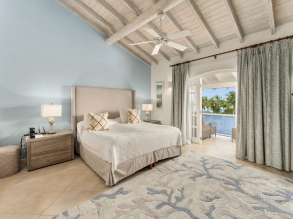 An aerial view of Port St. Charles No. 168, a luxurious villa nestled amidst lush greenery on the serene coast of Barbados. The villa features elegant architecture and expansive outdoor spaces, including a partially shaded terrace with a built-in BBQ, an intimate plunge pool overlooking a private dock and pier, and breathtaking views of the turquoise lagoon. The interior boasts tastefully furnished living and dining areas, sunlit guest bedrooms with en suite marble bathrooms, and a penthouse suite offering unrivaled vistas of the lagoon and sea. Sold fully furnished, this villa epitomizes luxury living in a secluded, picturesque setting.